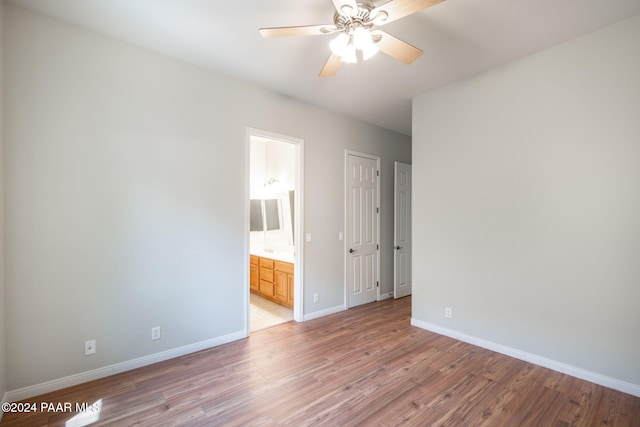 unfurnished bedroom with hardwood / wood-style floors, ensuite bath, and ceiling fan