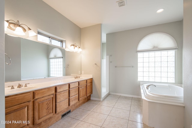 bathroom with tile patterned floors, a bathtub, and vanity