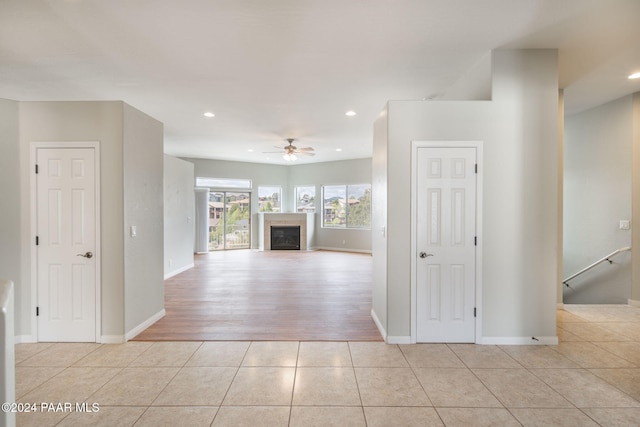 unfurnished living room featuring ceiling fan and light hardwood / wood-style floors