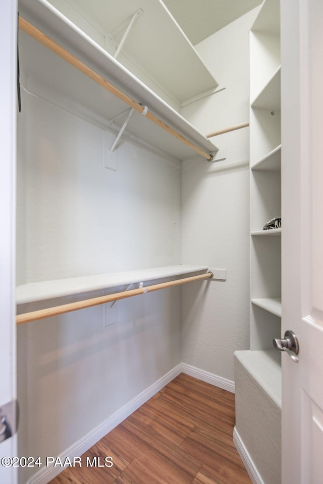 spacious closet featuring dark hardwood / wood-style flooring