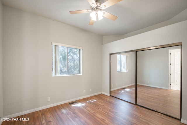 unfurnished bedroom with hardwood / wood-style flooring, ceiling fan, and a closet