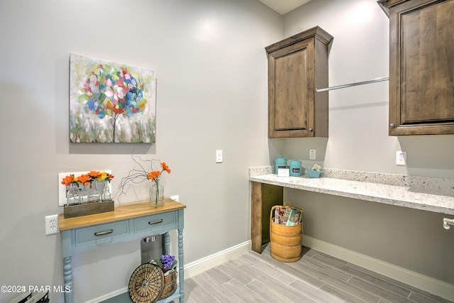 interior space featuring wood counters, dark brown cabinetry, and built in desk