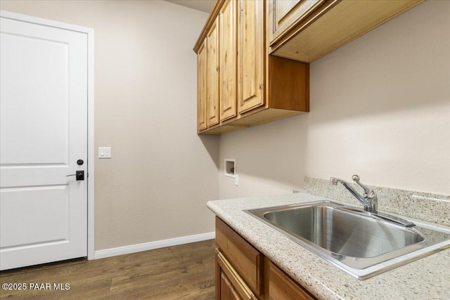 kitchen featuring a sink, baseboards, dark wood-type flooring, and light stone countertops