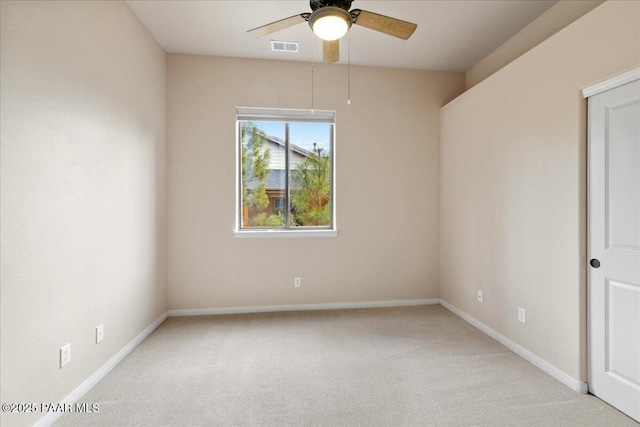 empty room with light carpet, visible vents, baseboards, and a ceiling fan