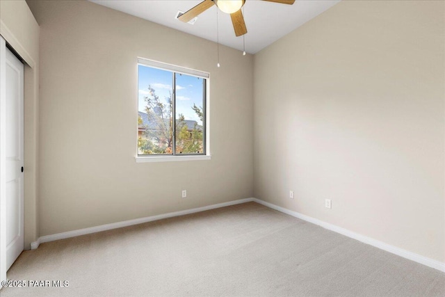 unfurnished bedroom with baseboards, light carpet, a closet, and a ceiling fan