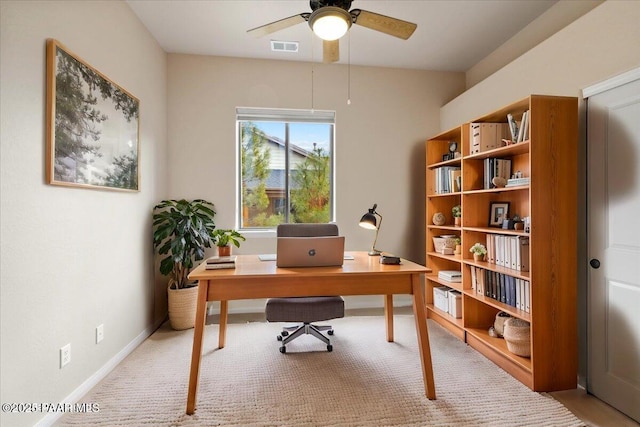 home office featuring light colored carpet, a ceiling fan, visible vents, and baseboards