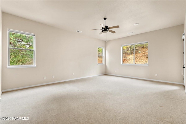 carpeted empty room with visible vents, baseboards, and ceiling fan