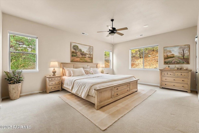 bedroom featuring visible vents, light carpet, and multiple windows