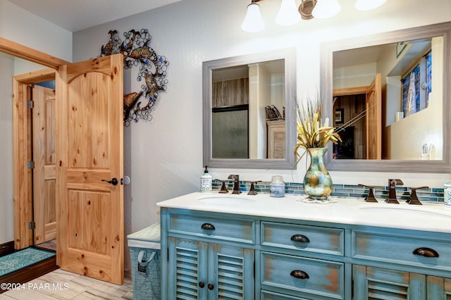 bathroom with hardwood / wood-style floors, vanity, and an enclosed shower