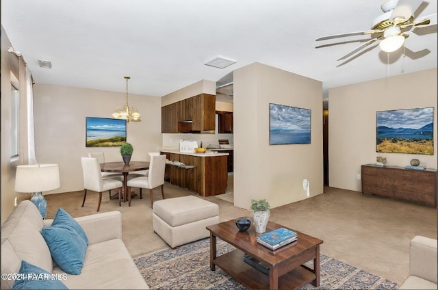 carpeted living room with ceiling fan with notable chandelier