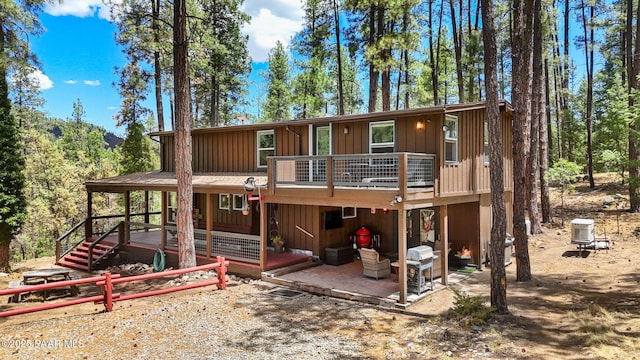 6231 S Champion Way Rd, Prescott, AZ 86303 - back of property with board and batten siding, a wooden deck, and a patio