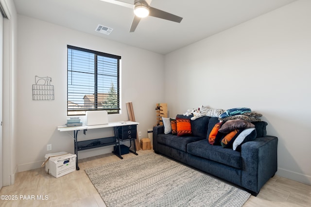 office area with baseboards, light wood-style floors, visible vents, and a ceiling fan