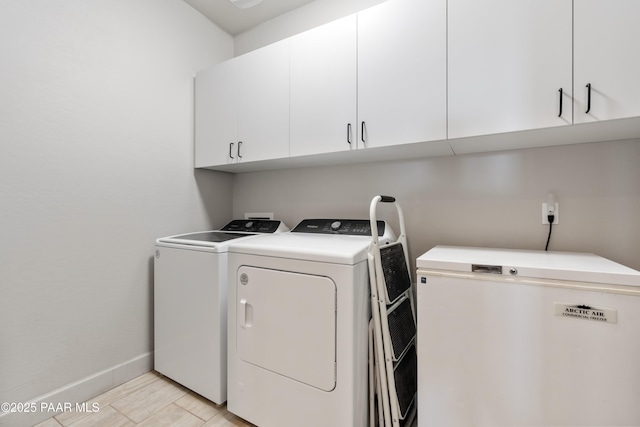 laundry area with cabinet space, baseboards, and separate washer and dryer