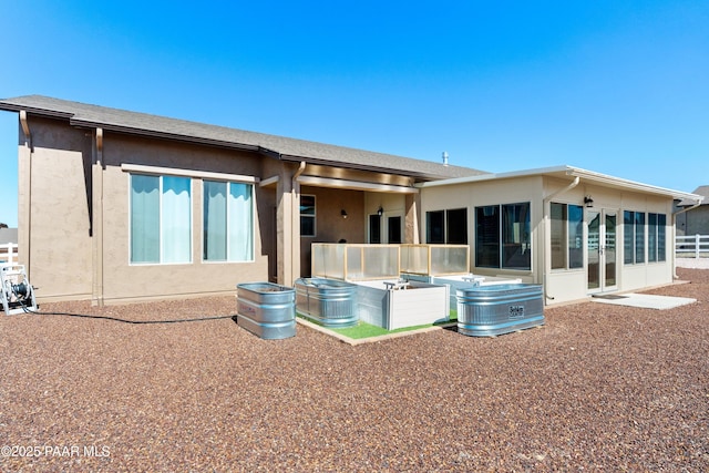 back of property featuring a sunroom and stucco siding