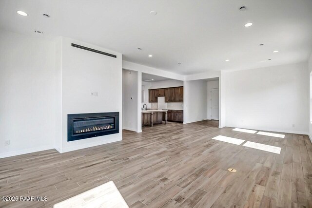 exercise area with ceiling fan and light wood-type flooring