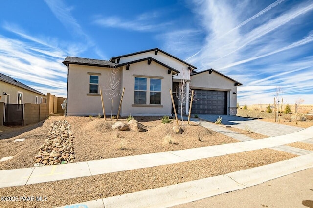 single story home featuring a garage, fence, concrete driveway, and stucco siding