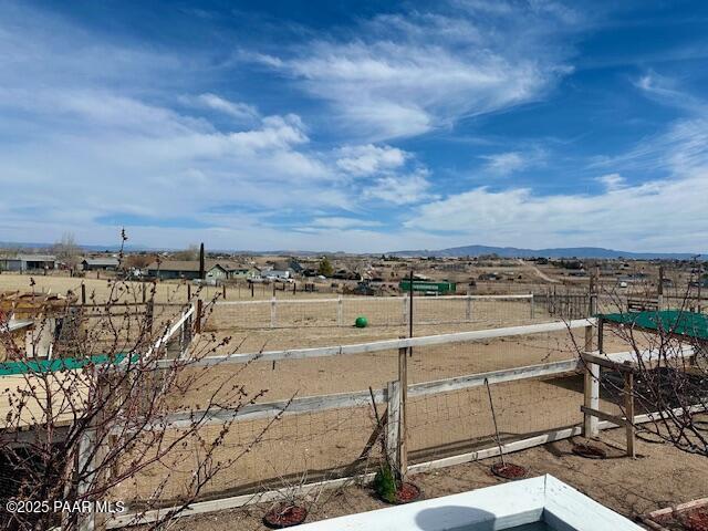 view of yard featuring fence and a rural view