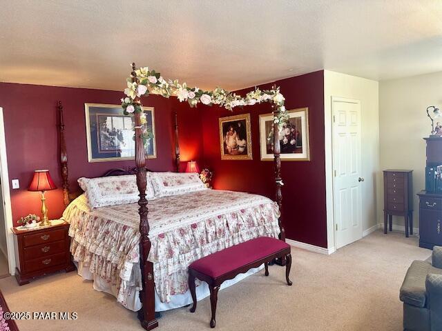 bedroom with baseboards and light carpet