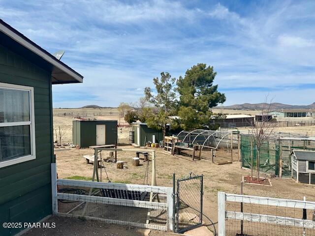 view of yard with a garden, an outbuilding, and fence