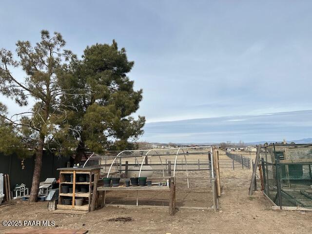 view of yard featuring a rural view, fence, and an outdoor structure