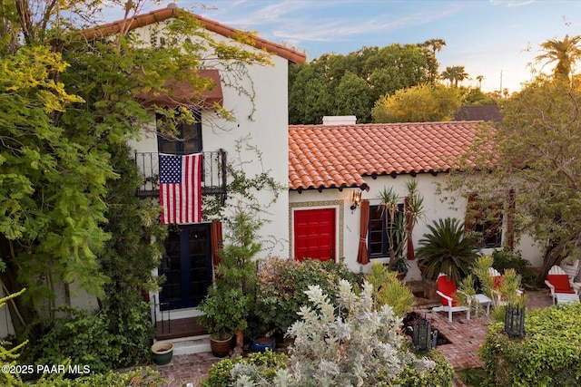 mediterranean / spanish house with a tile roof and stucco siding