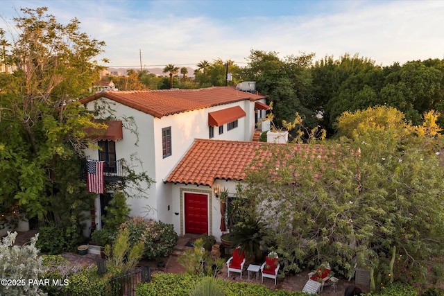 mediterranean / spanish-style house with stucco siding and a tiled roof