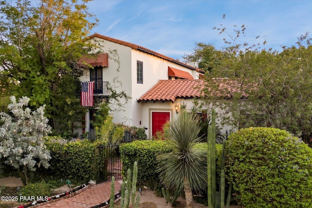 mediterranean / spanish home with a tile roof and stucco siding