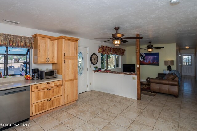 kitchen featuring a textured ceiling, ceiling fan, stainless steel appliances, and light brown cabinetry