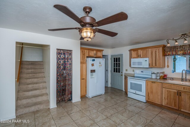 kitchen featuring a textured ceiling, ceiling fan, white appliances, and sink