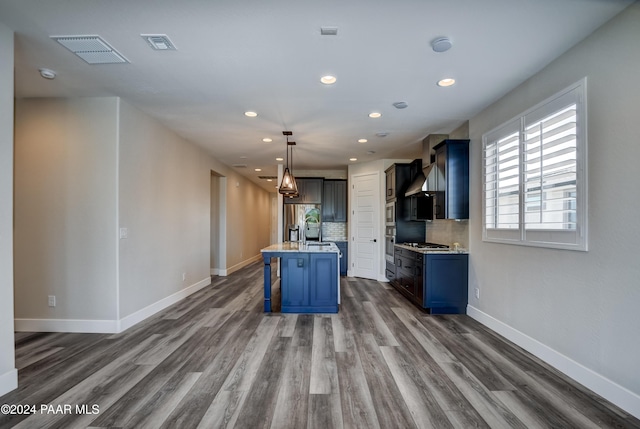 kitchen with a breakfast bar, sink, a center island, dark hardwood / wood-style floors, and hanging light fixtures