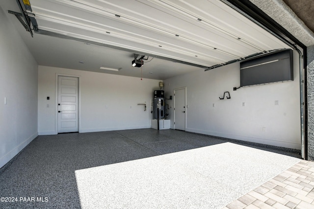 garage featuring hybrid water heater and a garage door opener