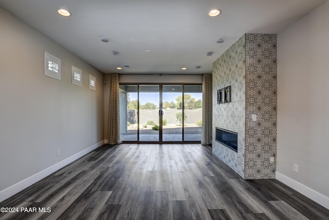 unfurnished living room featuring a fireplace and dark hardwood / wood-style flooring