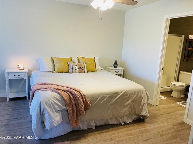 3070 Smokey Rd Unit 17E, Prescott, AZ 86301 - bedroom featuring a baseboard heating unit, light wood-style flooring, connected bathroom, and baseboards