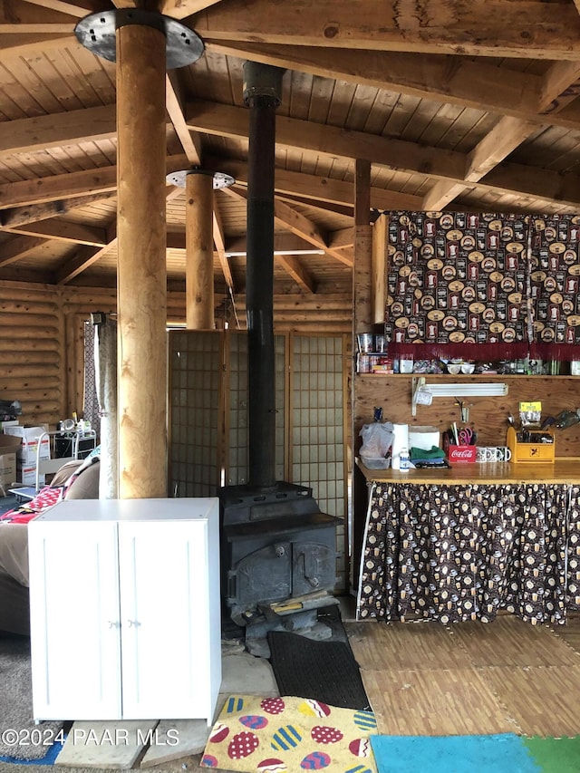 interior space with wood-type flooring, vaulted ceiling with beams, a wood stove, and wooden ceiling