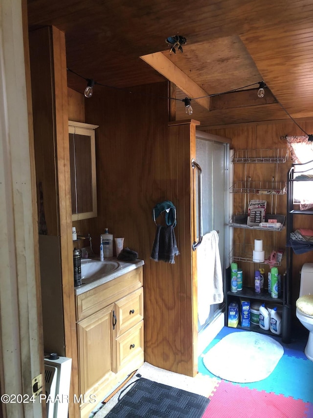 bathroom with vanity, toilet, wood walls, and wood ceiling