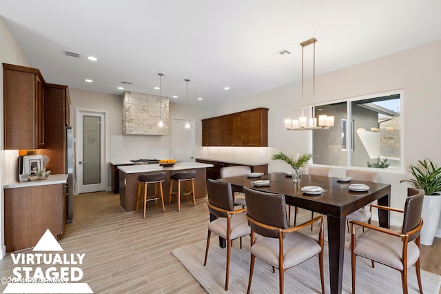 dining area featuring light wood-type flooring and an inviting chandelier