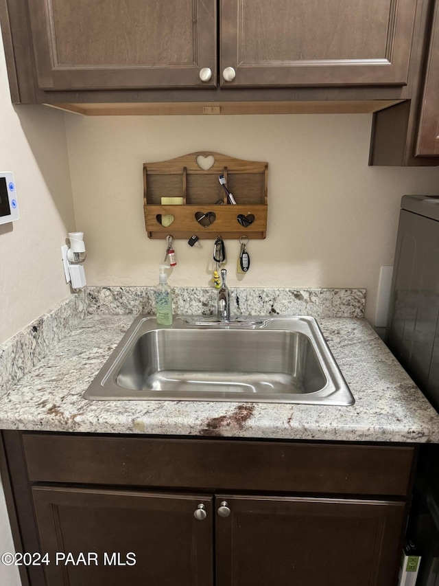 details featuring dark brown cabinetry and sink