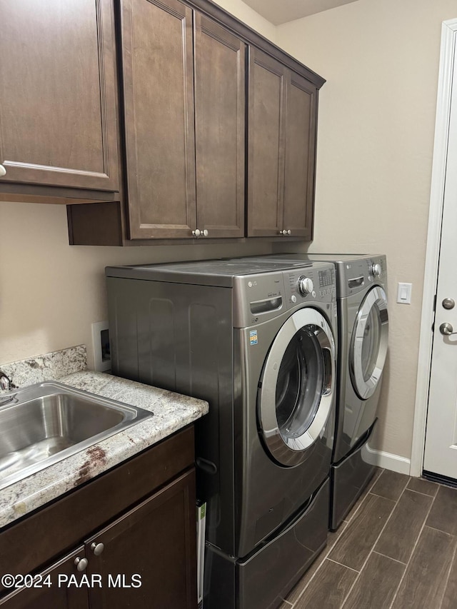 laundry area featuring cabinets, independent washer and dryer, and sink