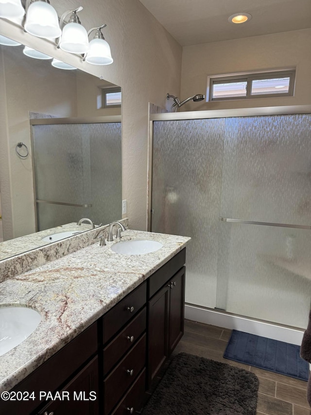 bathroom with a shower with door and vanity