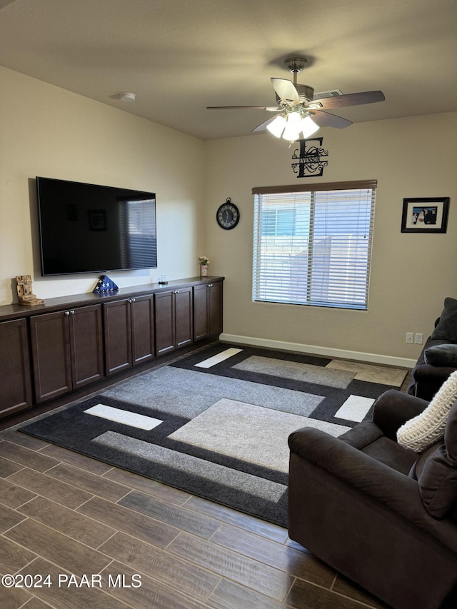 living room with ceiling fan and dark hardwood / wood-style flooring