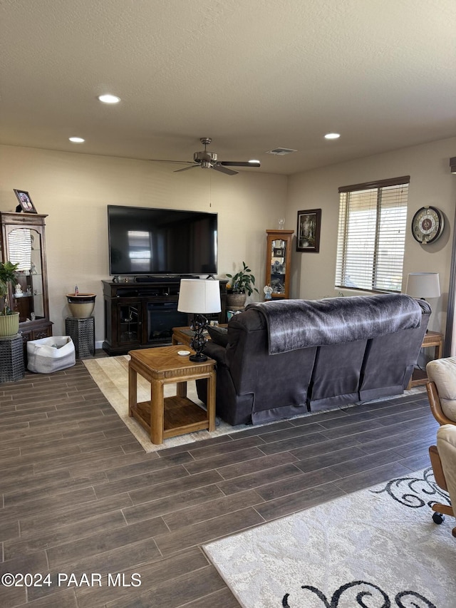 living room with ceiling fan and a textured ceiling