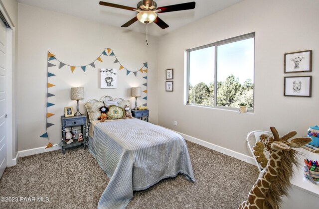 carpeted bedroom with a ceiling fan and baseboards