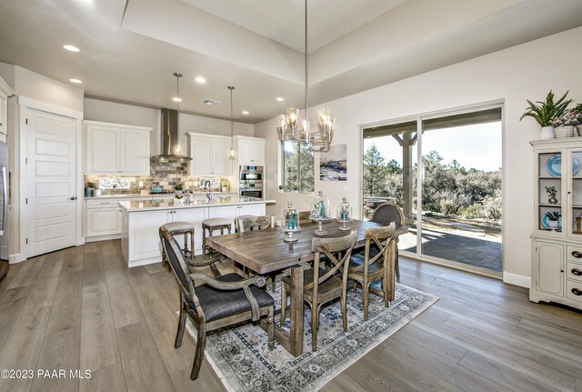 dining space with light wood finished floors, visible vents, recessed lighting, and an inviting chandelier