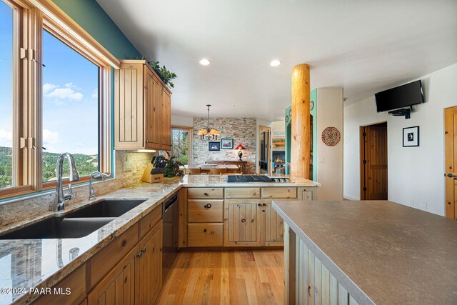 kitchen with plenty of natural light, sink, hanging light fixtures, and light hardwood / wood-style flooring