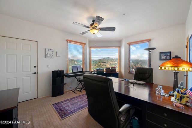 home office featuring light carpet and ceiling fan