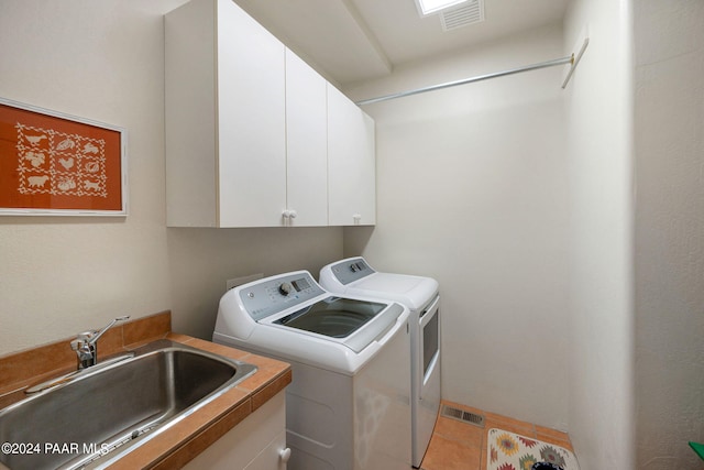 clothes washing area with cabinets, sink, and washing machine and dryer