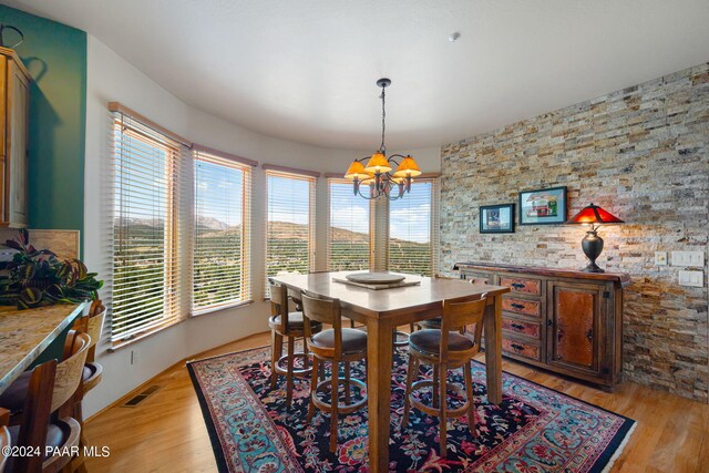 dining room featuring light wood-type flooring and a notable chandelier