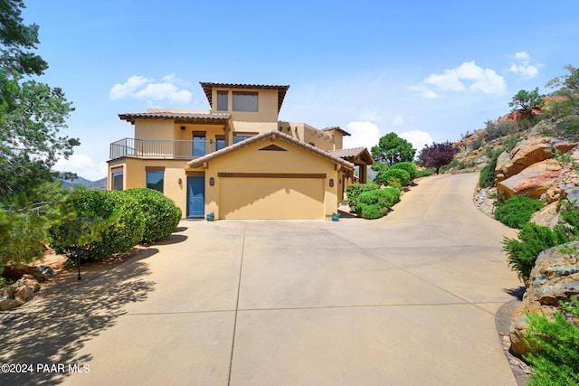 2253 Shadow Ridge Rd, Prescott, AZ 86305 - mediterranean / spanish house featuring a balcony, stucco siding, concrete driveway, a garage, and a tile roof