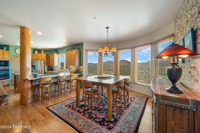 dining room with light hardwood / wood-style floors, sink, and a chandelier