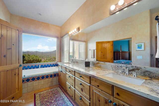 bathroom featuring tile patterned floors, tiled tub, and vanity